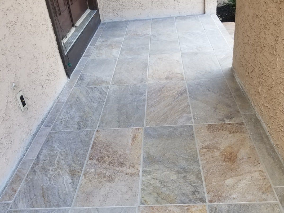 Slate-look tile flooring installed on a covered entry porch