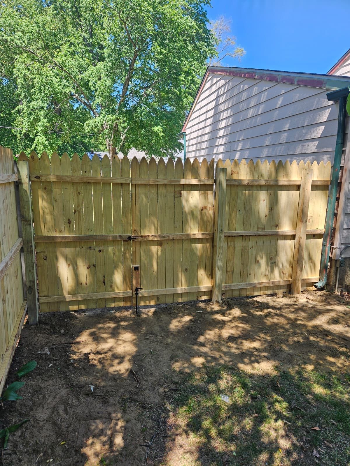 Newly installed wood privacy fence in a residential backyard